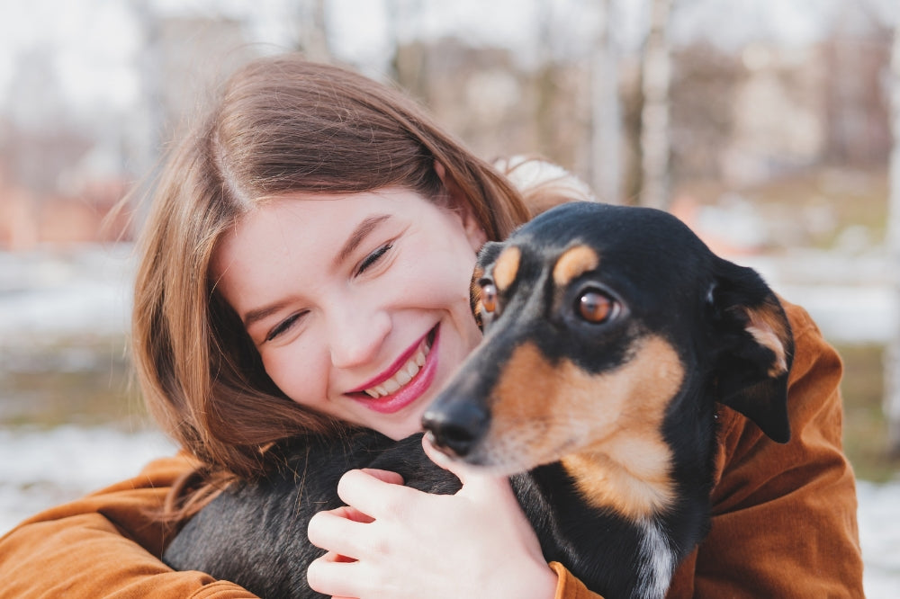 woman holding dachshund and smiling