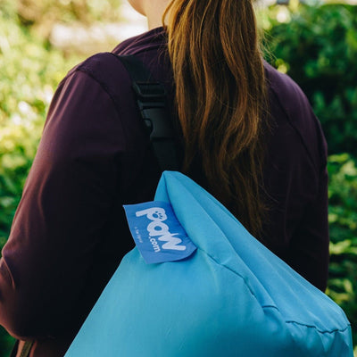 back of woman's head with travel bag for the dog bed on her shoulder